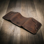 Trinity western trifold wallet in walnut brown leather, featuring intricate stitching and a subtle embossed logo.

