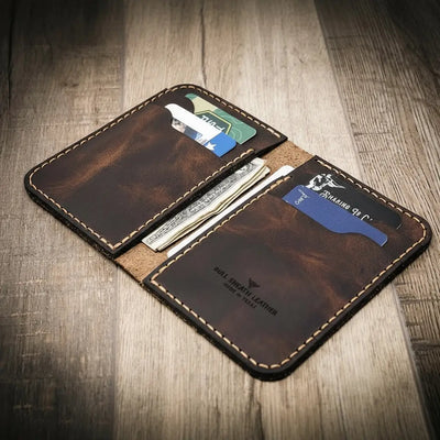 Handmade western vertical leather wallet in walnut brown color, open to show card slots and cash.