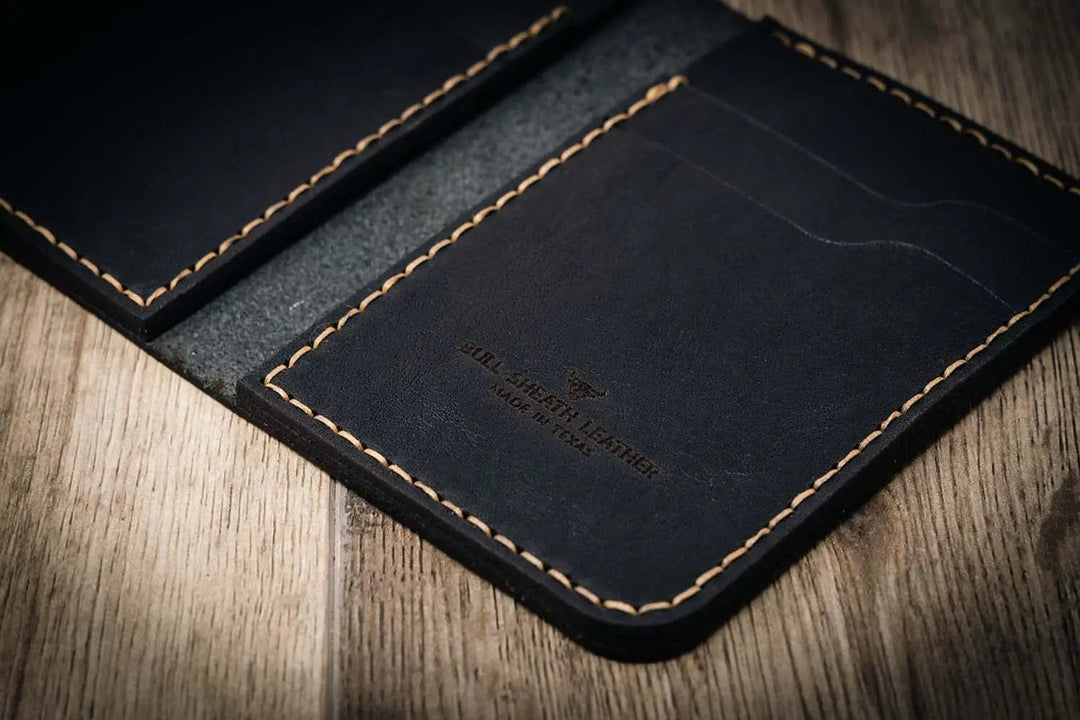 Handmade western vertical wallet in black leather, open to show stitching details and card slots.
