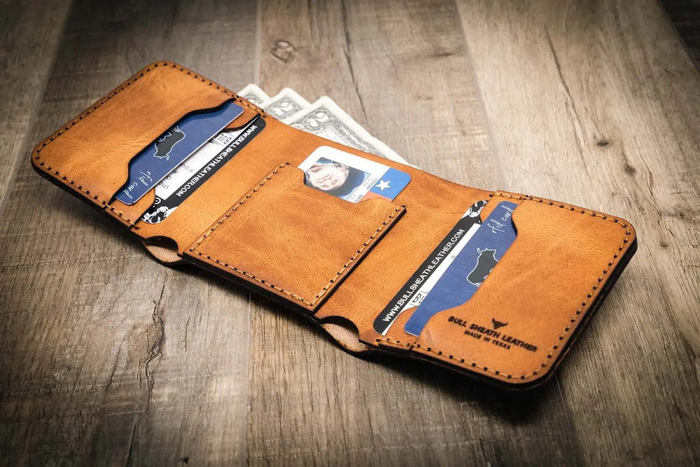 Trinity western trifold wallet in saddle tan leather, featuring multiple card slots and a cash compartment, handmade in the USA by Bull Sheath Leather.
