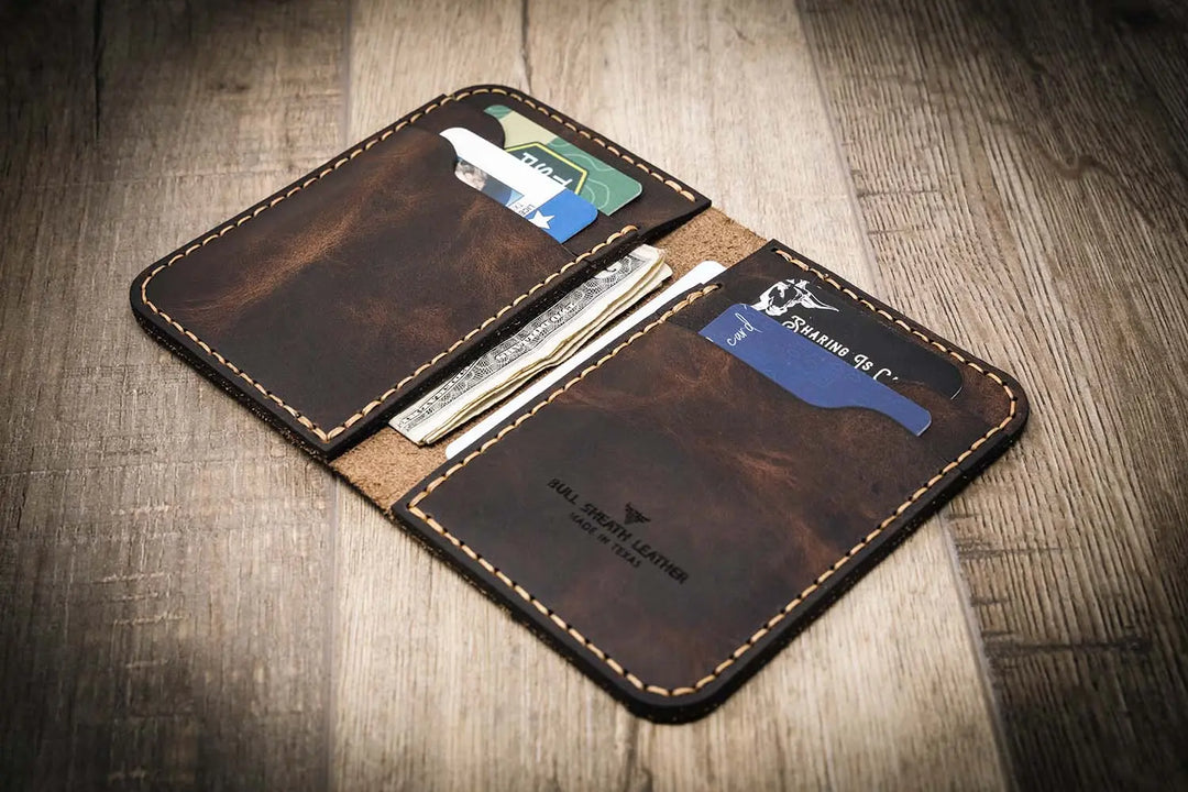 Handmade western vertical leather wallet in walnut brown color, open to show card slots and cash.