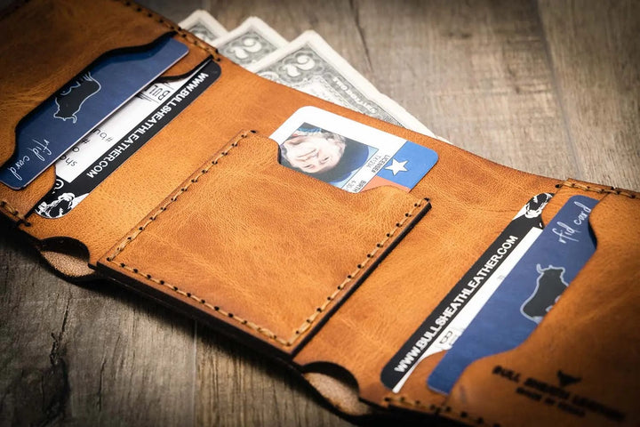 Trinity western trifold wallet in saddle tan leather, featuring multiple card slots and a cash compartment, showcasing a rustic and handcrafted design.