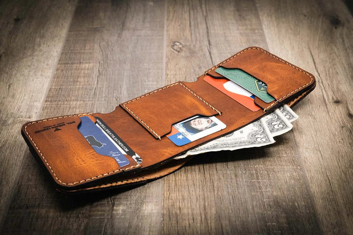 Trinity western trifold wallet in chestnut brown leather, open to display multiple card slots, an ID window, and a cash compartment, showcasing its handmade craftsmanship.