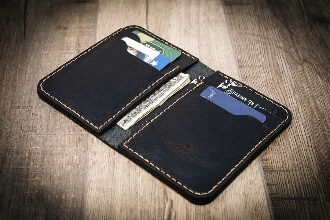 Western vertical wallet in black leather, with cards and cash inside. Handmade in Texas, USA