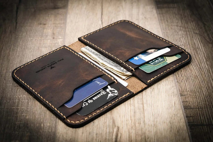 Handmade western vertical leather wallet in walnut brown color, open to show card slots and cash pocket.