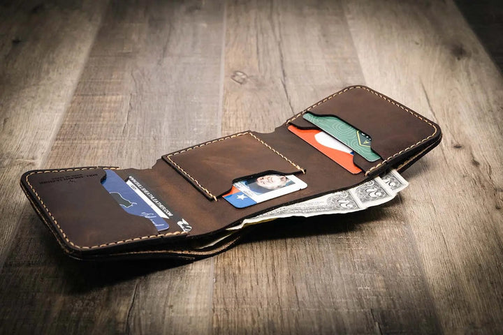 Trinity western trifold wallet in walnut brown leather, featuring multiple card slots and a cash compartment, displayed open with cards and cash inside.