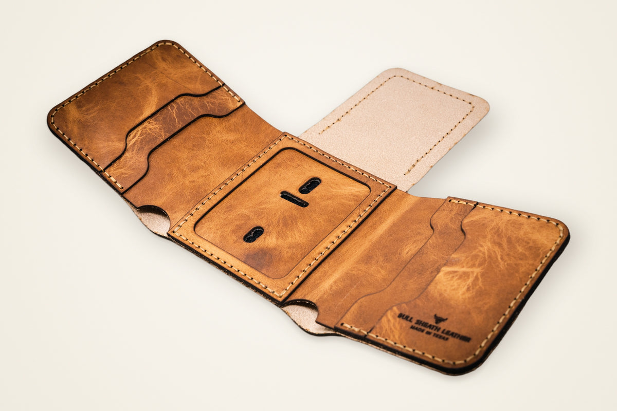 Badge Trifold Wallet on a cream background, showing its dedicated badge slot, eight-plus card slots, horween full-grain leather, burnished and reinforced