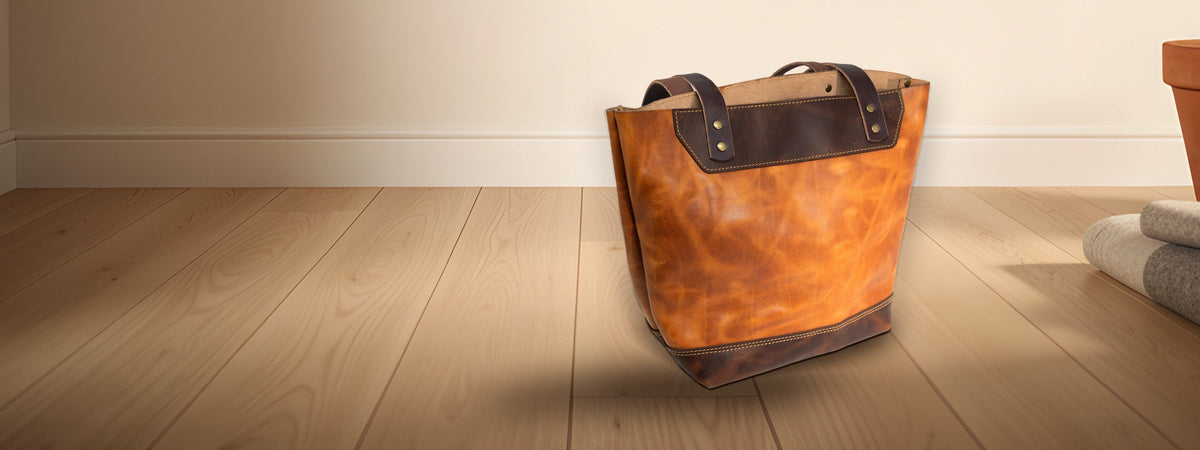 The Naomi Leather Tote Bag in chestnut full-grain leather standing on a light wood floor in a bright room